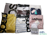 beaucoup de vêtements rangés dans des sacs posés sur la table