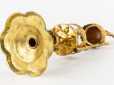 an image of a gold candle holder with a brown stone in the center