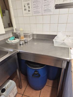 a kitchen with a sink and a trash can in it