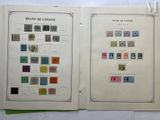 two pages of a book with stamps on them sitting on a table