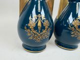 pair of blue vases with gold decoration on them on a white surface