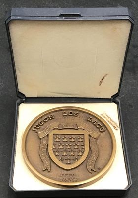 une médaille d'or dans un écrin noir posé sur une table