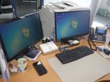 a desk with two computer monitors and a keyboard on it