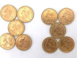 several gold coins are arranged in a row on a white surface