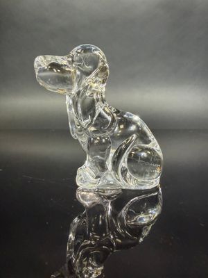 glass figurine of a dog sitting on top of a black surface