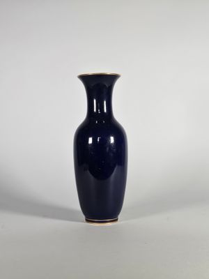 un vase bleu posé sur une surface blanche