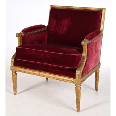 une image représentant une chaise en velours rouge ornée de passementeries dorées