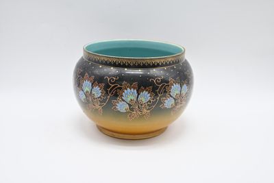 a blue and yellow vase sitting on a white surface