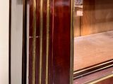 a large wooden cabinet with a glass door in the middle