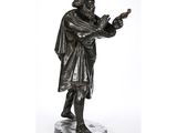 une statue en bronze représentant un homme tenant un oiseau dans la main