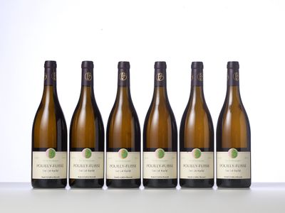 six bottles of white wine are lined up on a table