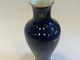 a small blue vase with a gold star on it