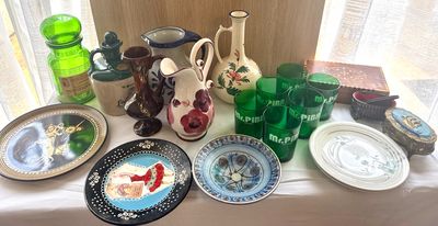 many plates and vases on a table near a window
