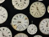 many different types of clocks displayed on a black surface