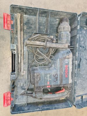une mallette à outils ouverte, contenant des outils, posée par terre