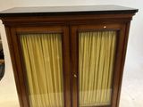 une petite armoire surmontée d'une porte vitrée