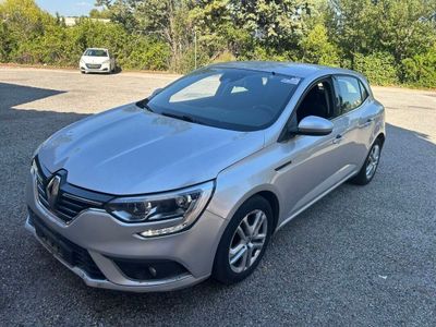 une voiture argentée garée sur un parking près d'une forêt