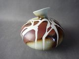 a brown and white vase sitting on a table