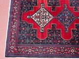 a red and blue oriental rug on a pink floor