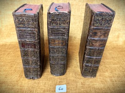 trois vieux livres posés sur une table l'un à côté de l'autre