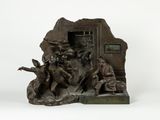 statue représentant un groupe de personnes assises sur un rocher, avec une horloge en arrière-plan
