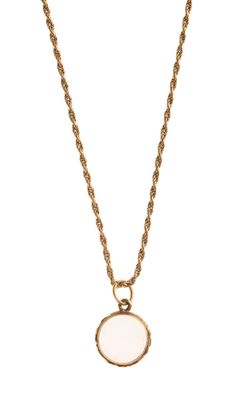 un collier en or avec un pendentif en pierre blanche au bout d'une chaîne