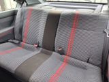 two seats in the back of a car with a red stripe
