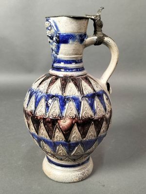 un vase bleu et blanc muni d'une anse, sur fond gris