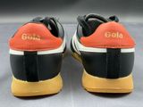 the soles of a pair of black and orange shoes on a gray surface