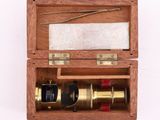 une vieille boîte en bois contenant un télescope, posée sur une surface blanche