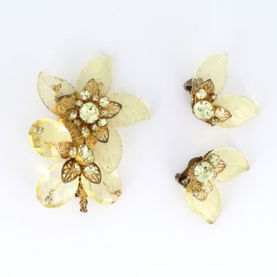 deux broches en forme de fleur de couleur dorée et une paire de boucles d'oreilles