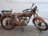 a brown motorcycle that is parked in front of a window