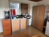 a small office with a printer and cabinets in it