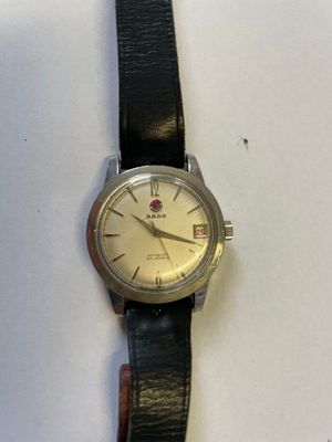 une photo d'une montre-bracelet posée sur une surface blanche