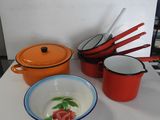 Plusieurs casseroles et poêles sont posées sur une table, à côté d'un saladier et d'une cuillère.