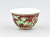 a red and green bowl with a dragon design on it
