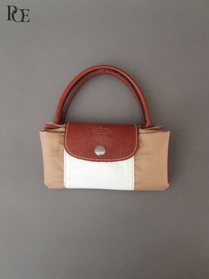 un sac à main marron et blanc accroché au mur