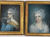 deux portraits encadrés représentant des femmes en robe bleue, avec un oiseau posé sur l'épaule