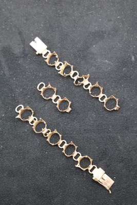 a close up of a chain bracelet on a black surface
