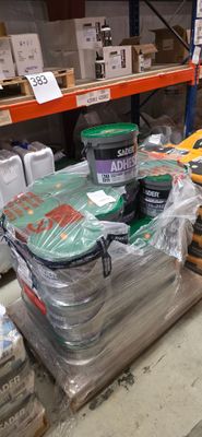 Des cartons de peinture et d'autres articles sont empilés sur une étagère dans un entrepôt