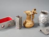 trois vases, une boîte et une boîte posée sur une table