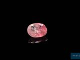 a close up of a pink diamond on a black surface