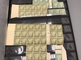 two sheets of green and white postages on display in a black case