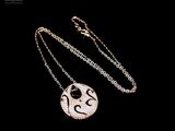 silver necklace with a black and white image of a bird