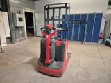 a red and black fork lift truck in a garage