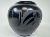 a black vase sitting on a white surface