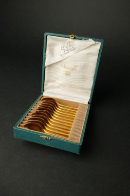 une boîte verte contenant six cuillères en or
