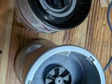 two exhaust fans sitting on a wooden floor next to a cardboard box