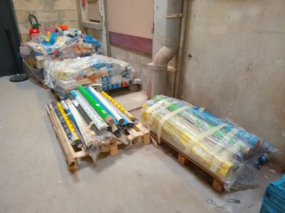 de nombreux crayons de couleur disposés sur des palettes dans une pièce