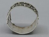 an image of a silver ring on a table with a gray background